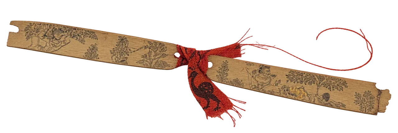 A strip of palm leaf with incised figures, tied with red thread.